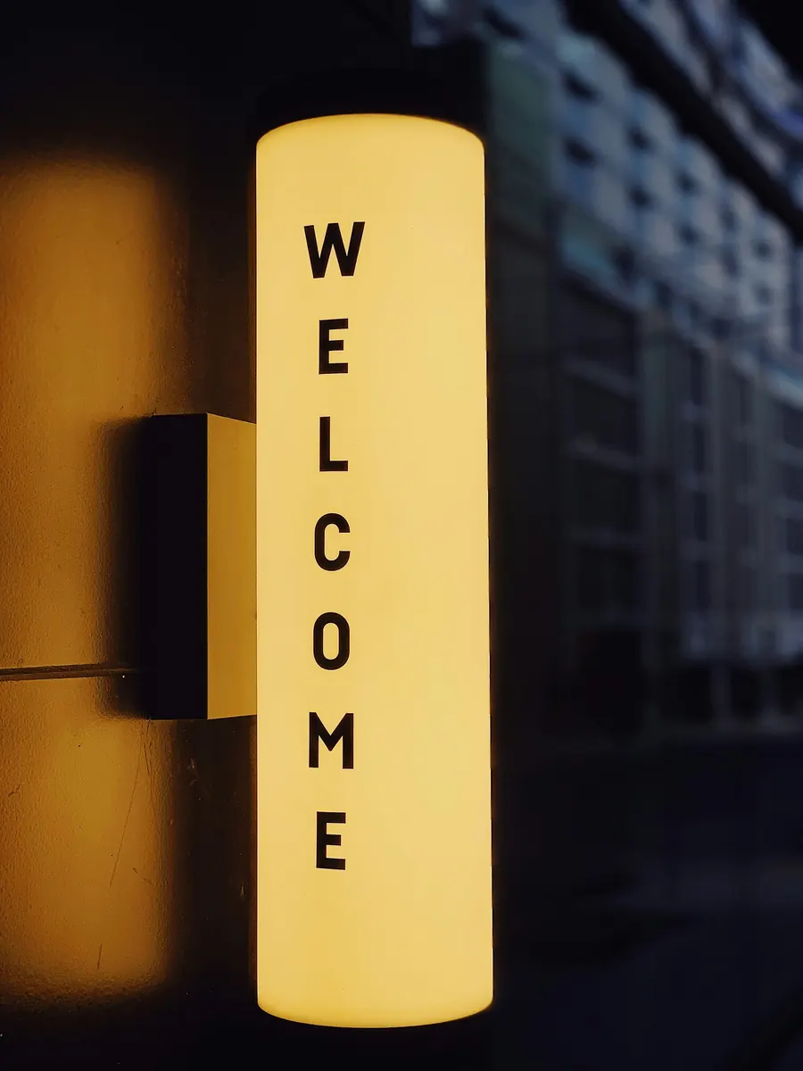 Bright yellow « WELCOME » sign at the entrance of a building, symbol of an onboarding that truly welcomes new employees